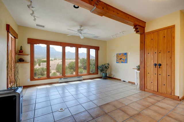 interior space with ceiling fan, beam ceiling, a baseboard heating unit, light tile patterned floors, and track lighting