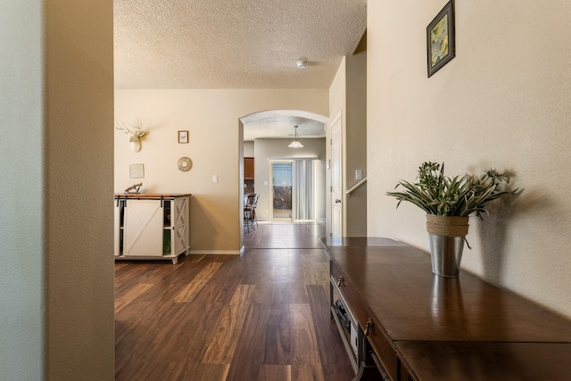 hall featuring a textured ceiling and dark hardwood / wood-style flooring