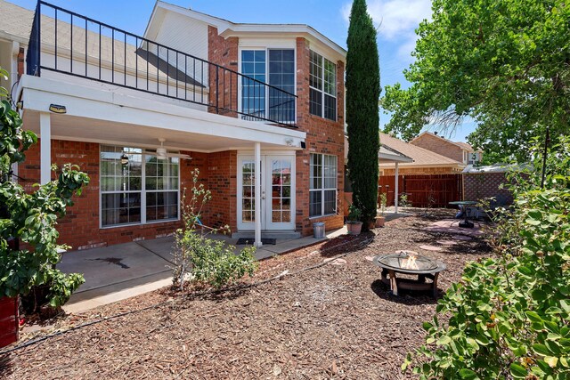 rear view of property with an outdoor fire pit, a patio, and a balcony