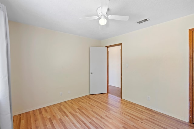 spare room featuring light hardwood / wood-style floors, ceiling fan, and a textured ceiling