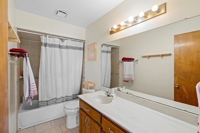 full bathroom with tile patterned floors, toilet, shower / tub combo with curtain, and vanity