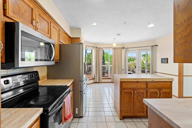 doorway to outside with light tile patterned floors, french doors, and a textured ceiling