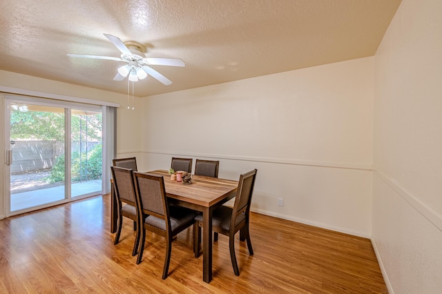 dining area with light hardwood / wood-style floors, a textured ceiling, and ceiling fan