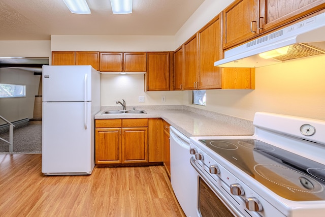 kitchen with light wood-type flooring, sink, and white appliances