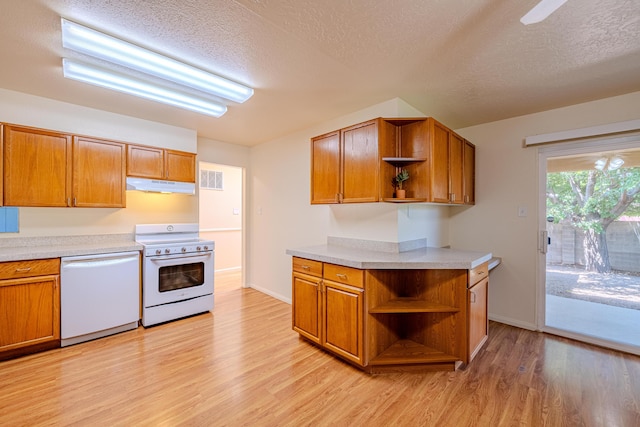 kitchen with white appliances, a textured ceiling, and light hardwood / wood-style flooring