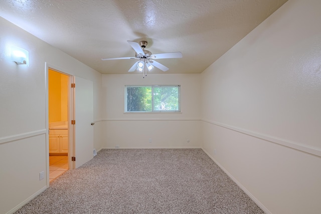 carpeted empty room featuring a textured ceiling and ceiling fan