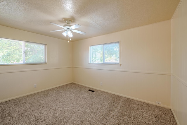 empty room with ceiling fan, a textured ceiling, and carpet flooring