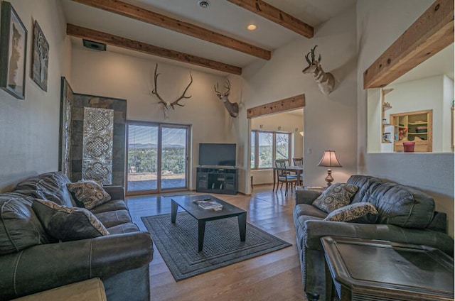 living room with beamed ceiling and light hardwood / wood-style flooring