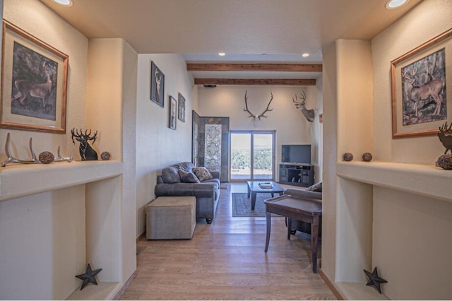 living room featuring light hardwood / wood-style flooring and beam ceiling