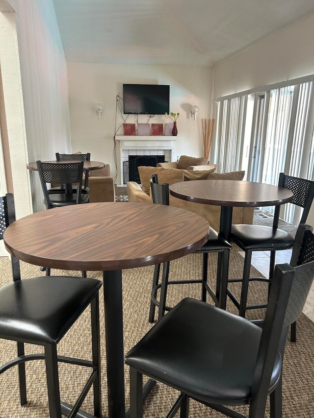 dining space featuring a fireplace and carpet flooring