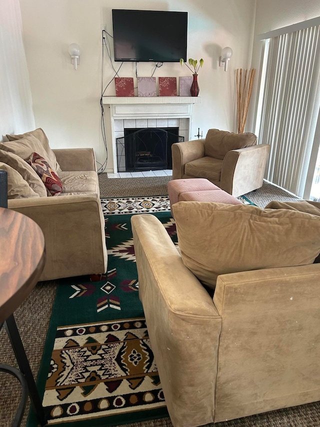 living room with a tiled fireplace and carpet flooring