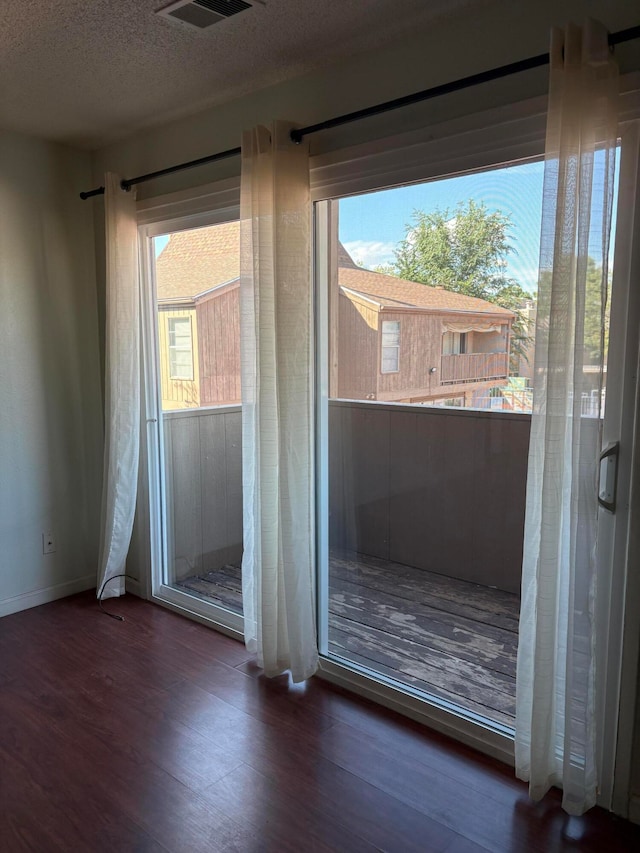 entryway with hardwood / wood-style flooring, a textured ceiling, and a healthy amount of sunlight