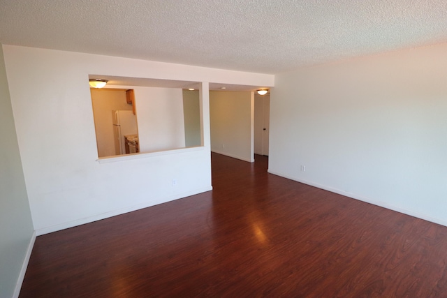 empty room featuring dark hardwood / wood-style floors and a textured ceiling