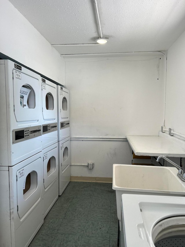 clothes washing area featuring independent washer and dryer, stacked washer / dryer, and a textured ceiling