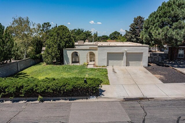 view of front of home with a garage and a front lawn