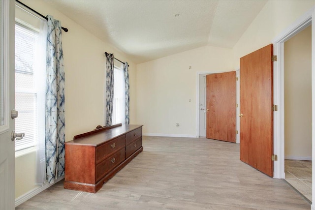 interior space with lofted ceiling and light hardwood / wood-style flooring