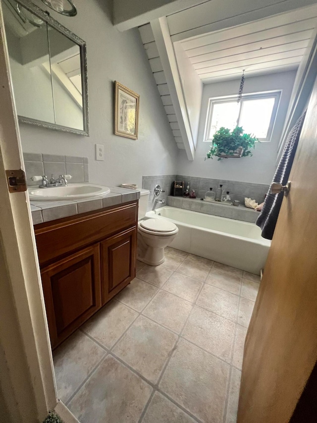 bathroom with lofted ceiling with beams, a washtub, tile patterned floors, toilet, and vanity