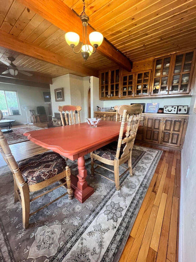 dining room with beamed ceiling, wood-type flooring, a notable chandelier, and wood ceiling