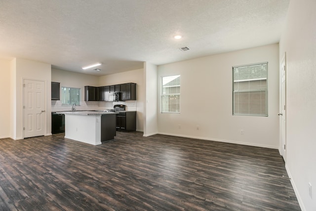 6213 White Hawk Dr NE, Rio Rancho, NM 87144 - kitchen with open floor plan, dark wood finished floors, a kitchen island, light countertops, and a textured ceiling