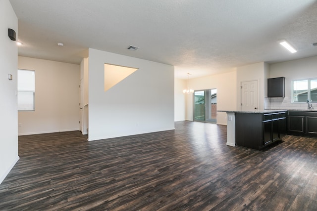 6213 White Hawk Dr NE, Rio Rancho, NM 87144 - kitchen with open floor plan, dark wood finished floors, a chandelier, and dark cabinetry