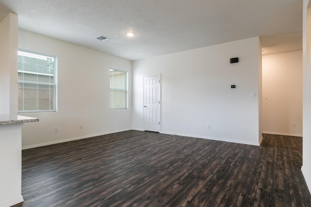 6213 White Hawk Dr NE, Rio Rancho, NM 87144 - unfurnished room with dark wood-style floors, healthy amount of natural light, and a textured ceiling