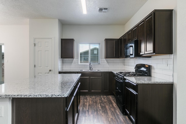 6213 White Hawk Dr NE, Rio Rancho, NM 87144 - kitchen featuring black appliances, dark wood-style floors, a textured ceiling, light stone counters, and a kitchen island
