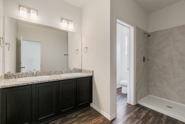 6213 White Hawk Dr NE, Rio Rancho, NM 87144 - full bathroom with double vanity, a tile shower, and wood finished floors