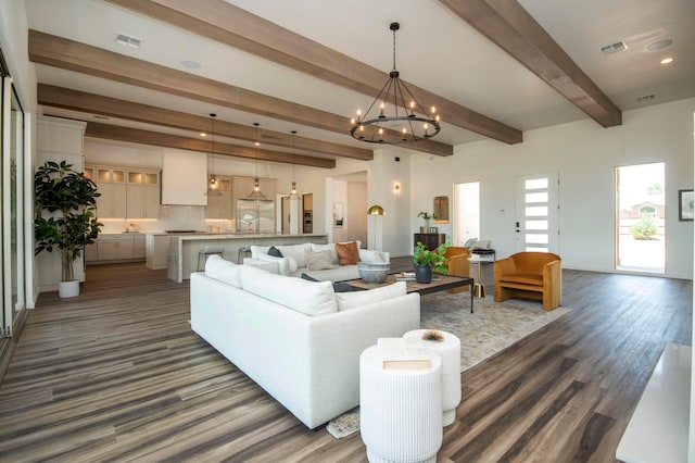 living room featuring dark hardwood / wood-style floors, beam ceiling, and a chandelier