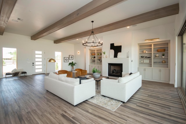 living room with beamed ceiling, a notable chandelier, and hardwood / wood-style flooring