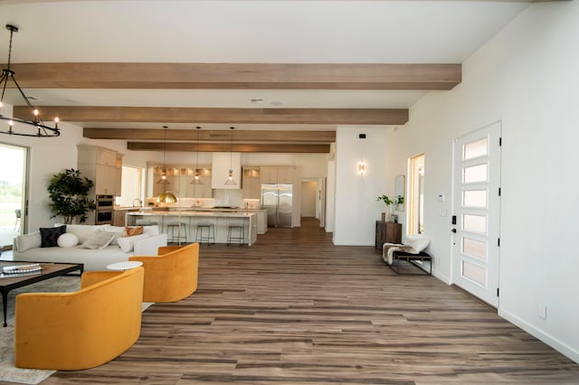 living room featuring beam ceiling, dark hardwood / wood-style flooring, and an inviting chandelier