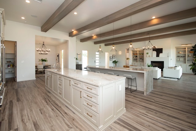 kitchen featuring a spacious island, hardwood / wood-style flooring, hanging light fixtures, and white cabinets