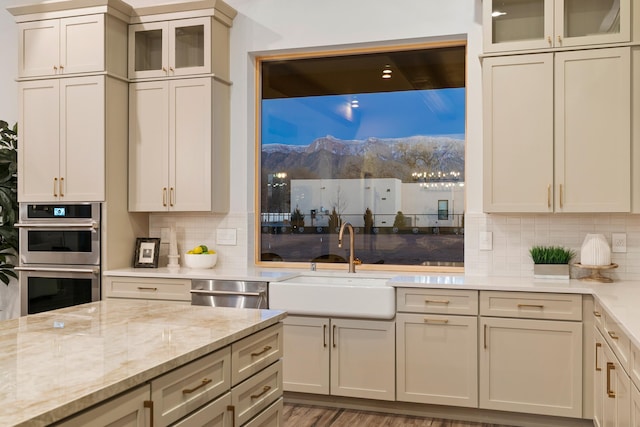 kitchen featuring cream cabinets, stainless steel appliances, and backsplash