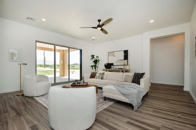 living room featuring ceiling fan and dark hardwood / wood-style floors