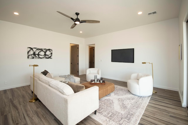 living room featuring dark wood-type flooring and ceiling fan