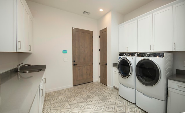 laundry area with washer and dryer, cabinets, and sink