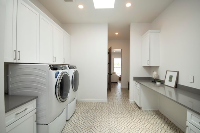 laundry room with washing machine and dryer and cabinets