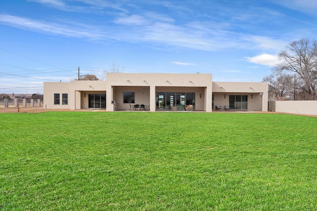 rear view of property featuring a patio area and a lawn