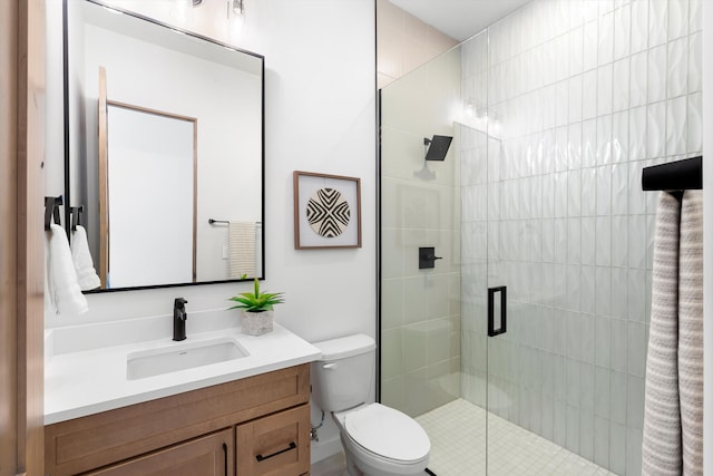 bathroom featuring a shower with door, toilet, and vanity