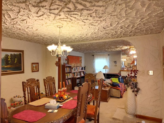 carpeted dining room featuring a chandelier