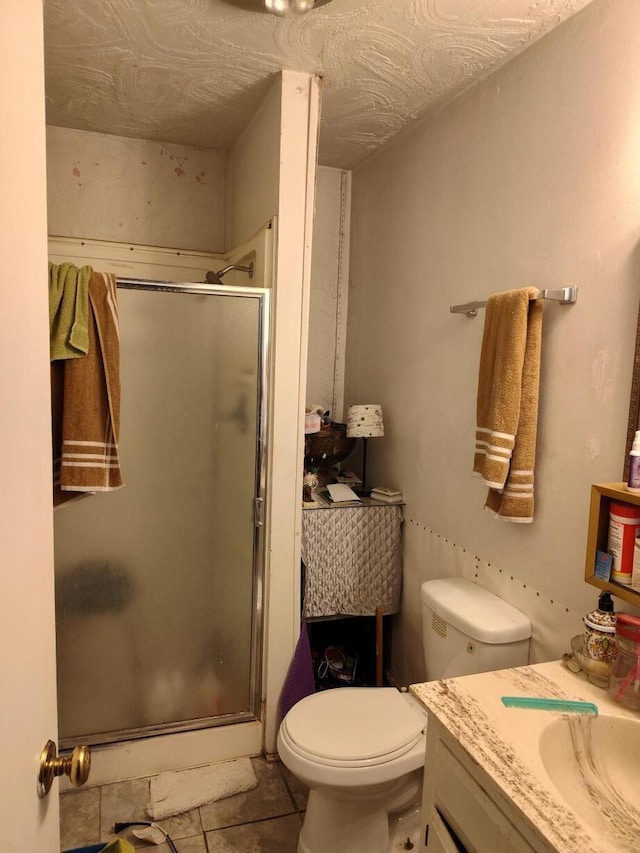 bathroom featuring tile patterned flooring, an enclosed shower, vanity, and toilet