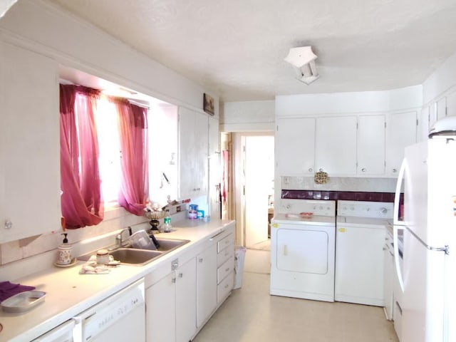 kitchen with sink, washing machine and clothes dryer, white cabinetry, and white appliances