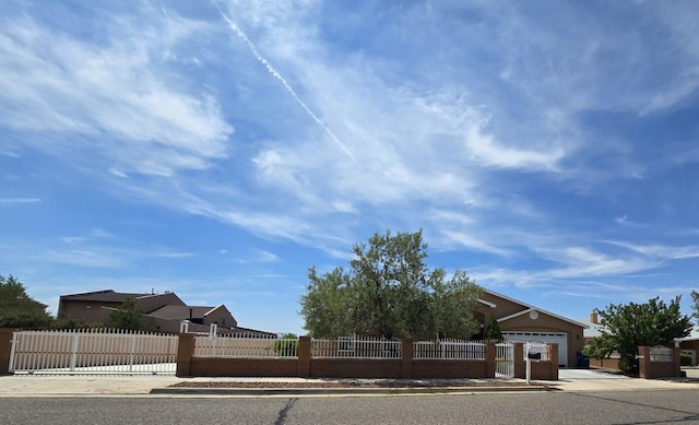 view of yard featuring a fenced front yard, a garage, and driveway