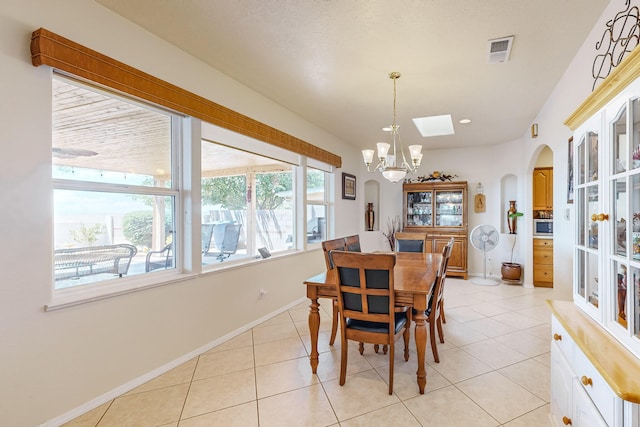 dining area with a notable chandelier, visible vents, baseboards, and light tile patterned flooring