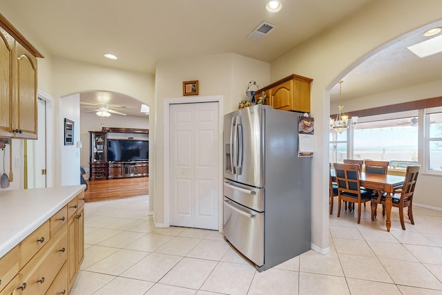 kitchen featuring arched walkways, stainless steel refrigerator with ice dispenser, and light tile patterned flooring