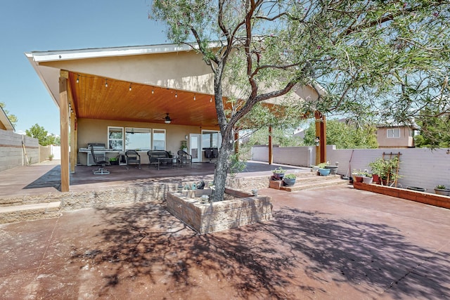 rear view of house featuring a patio, a fenced backyard, and stucco siding