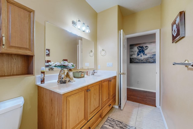 bathroom with tile patterned floors, toilet, vanity, and baseboards