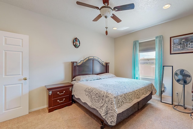 bedroom featuring baseboards, light colored carpet, and a ceiling fan