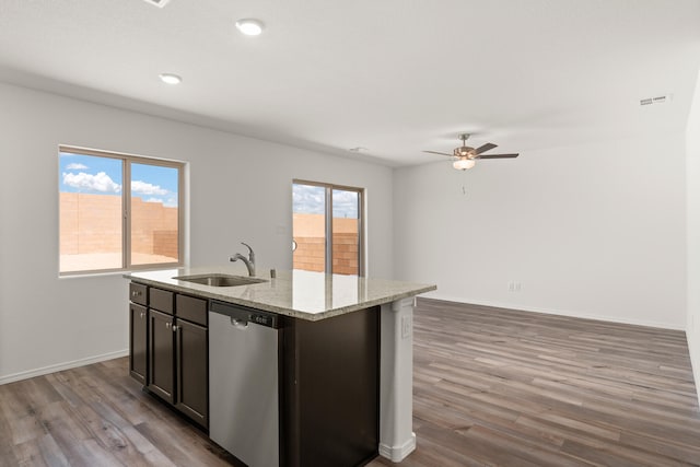 kitchen featuring dishwasher, sink, a kitchen island with sink, dark brown cabinetry, and light hardwood / wood-style floors