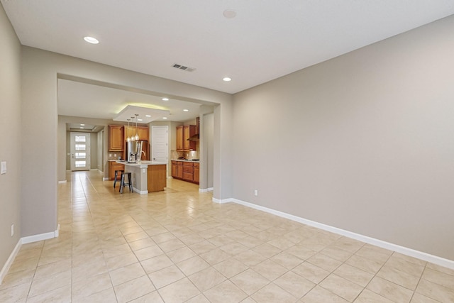 unfurnished living room with recessed lighting, visible vents, and baseboards