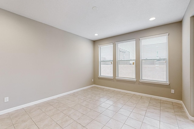 unfurnished room with baseboards, a textured ceiling, and recessed lighting